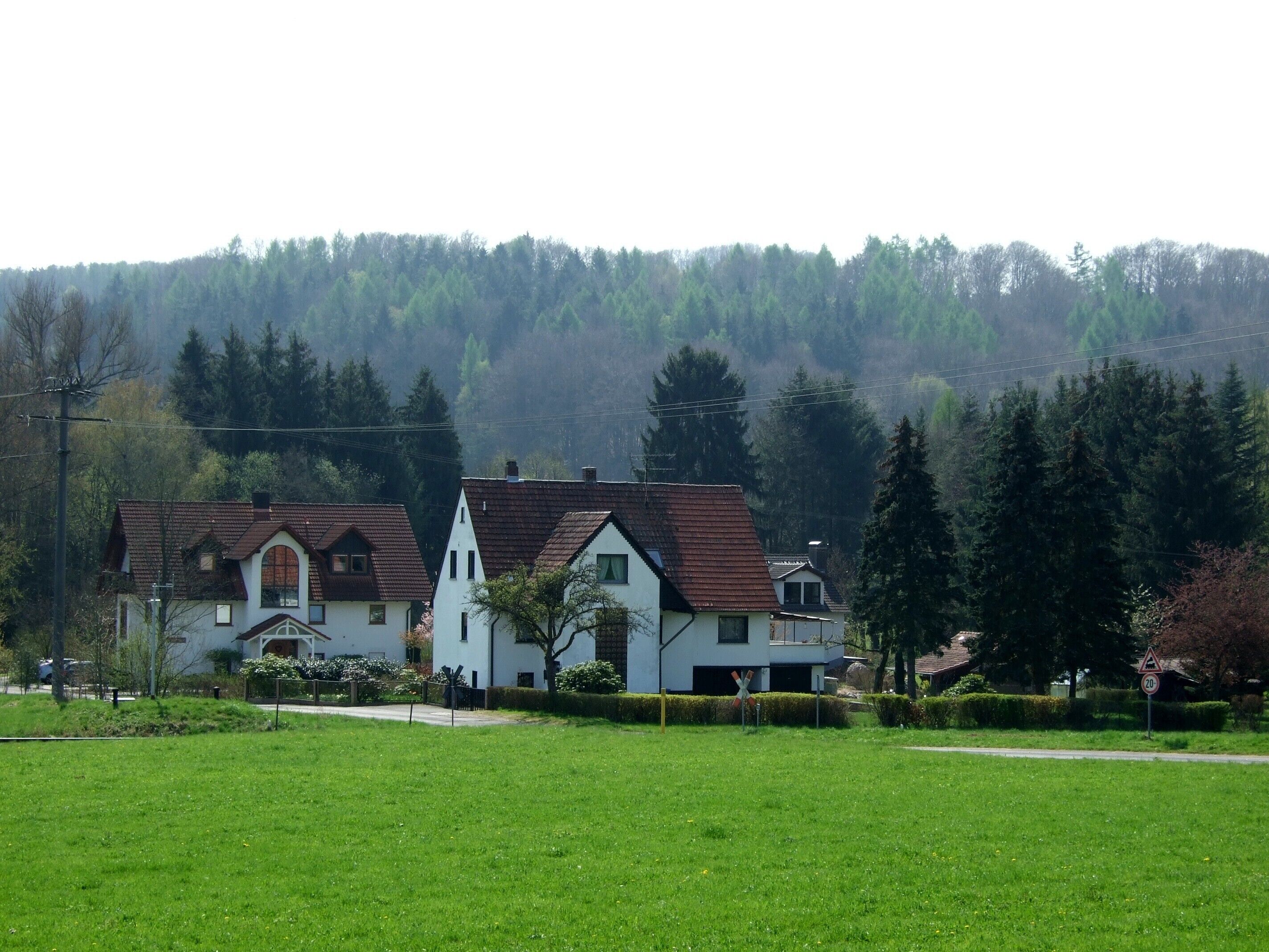 A rural area with houses and a green field.