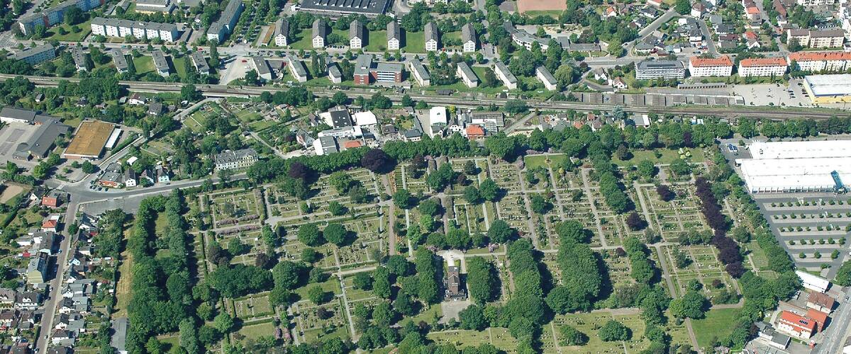 An aerial view of a cemetery surrounded by residential buildings and roads.
