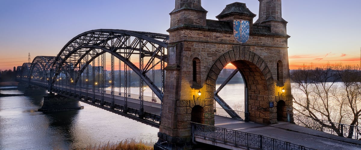 Eine Stahlbrücke mit steinernen Bögen und einem Fluss darunter.