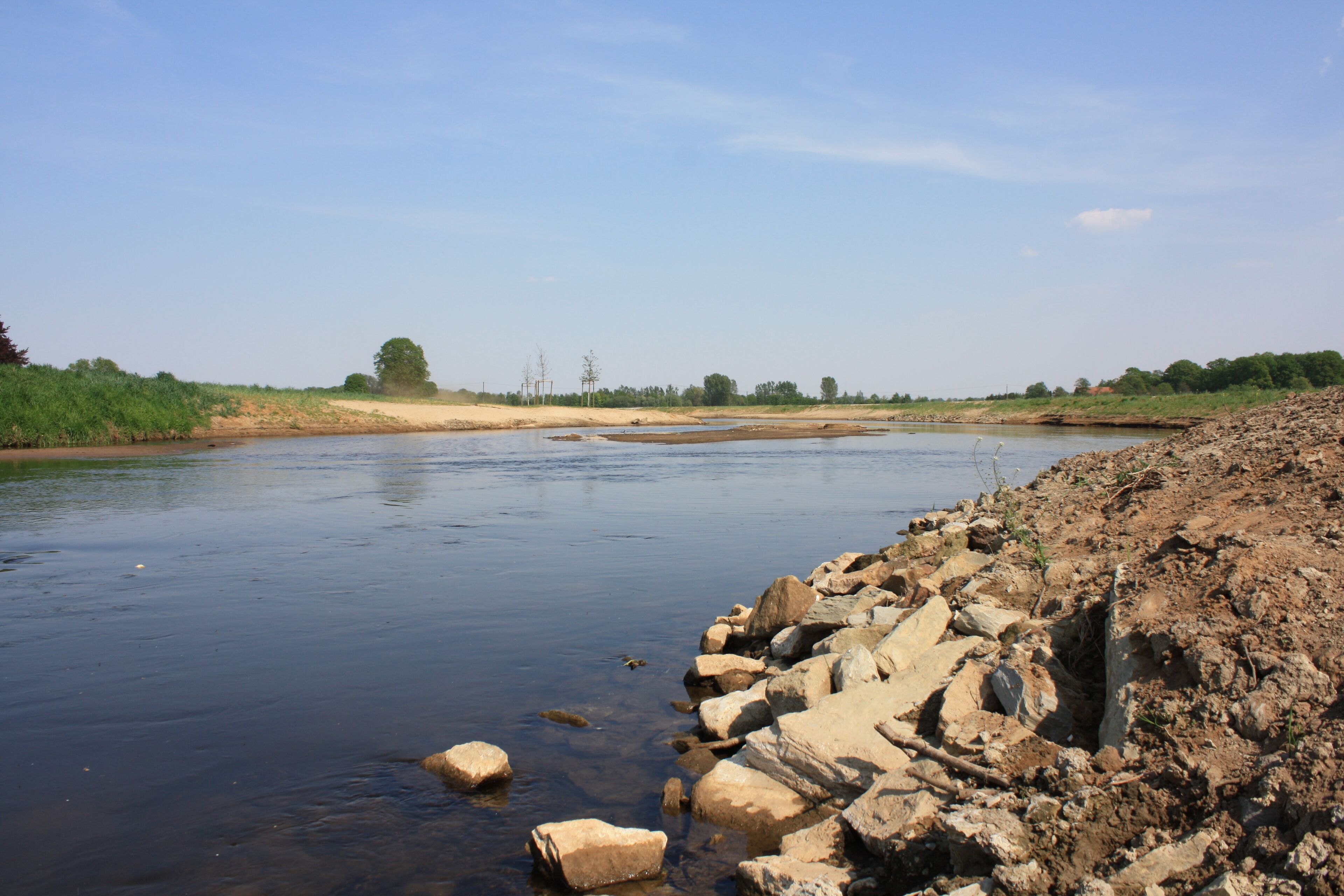 A river with rocky banks and sparse vegetation.