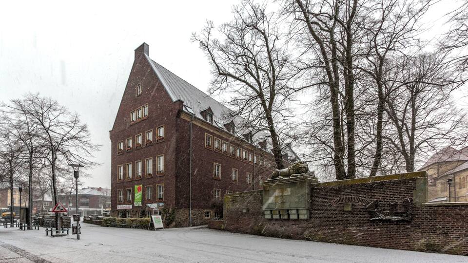 Town Hall and war memorial while snow falls, Dülmen, North Rhine-Westphalia, Germany