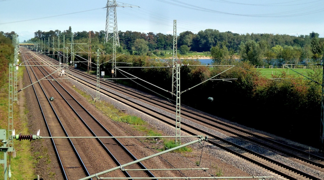 Bahnstrecke Düsseldorf–Duisburg am Angermunder See; hinten Freileitungsmast (Bl. 4142 M16, 380/220/110 kV)