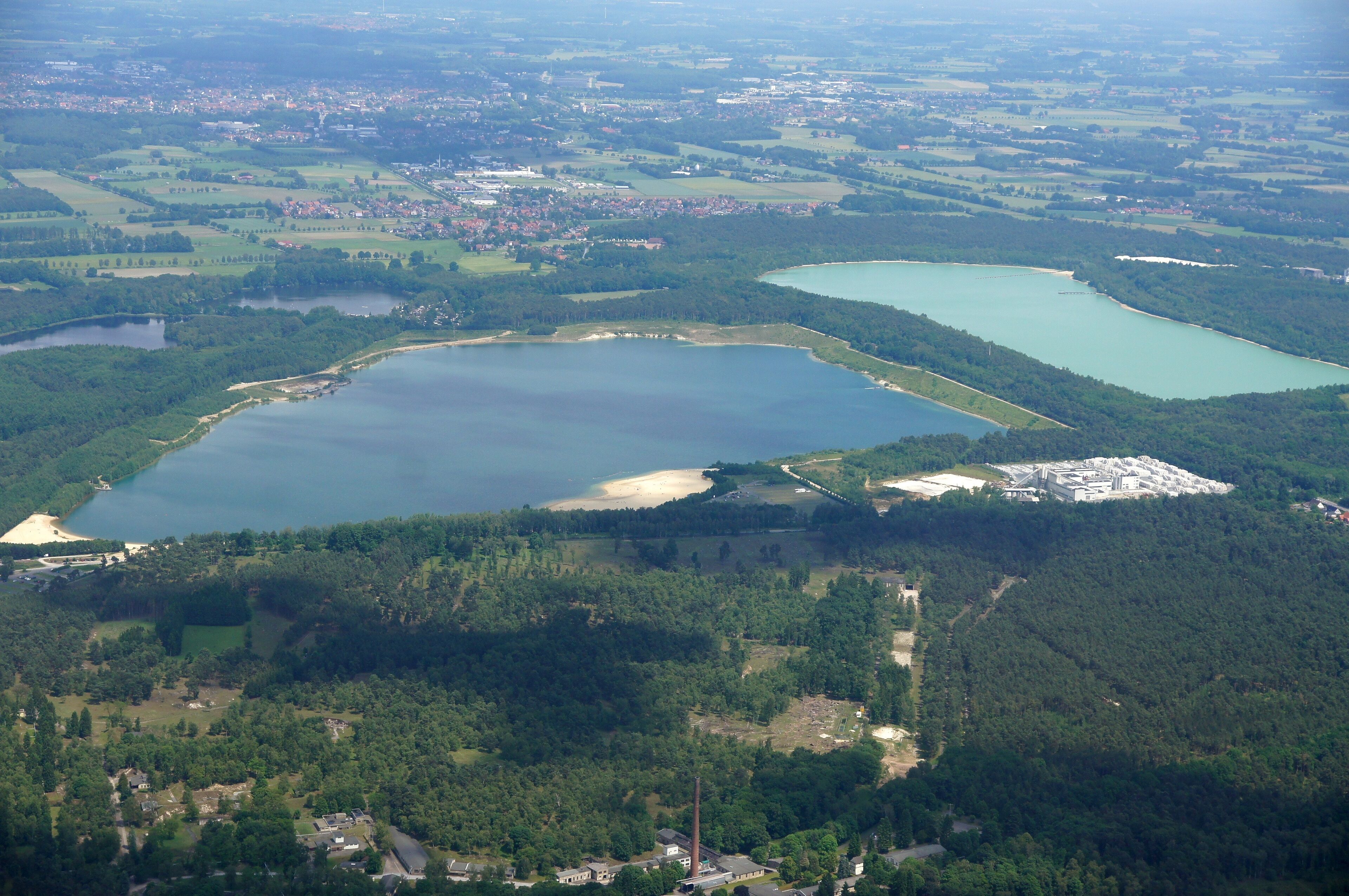 A large lake surrounded by forested areas and a small town.