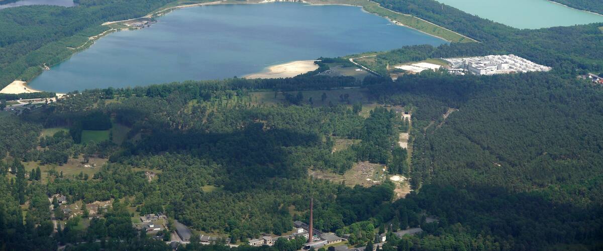 A large lake surrounded by forested areas and a small town.