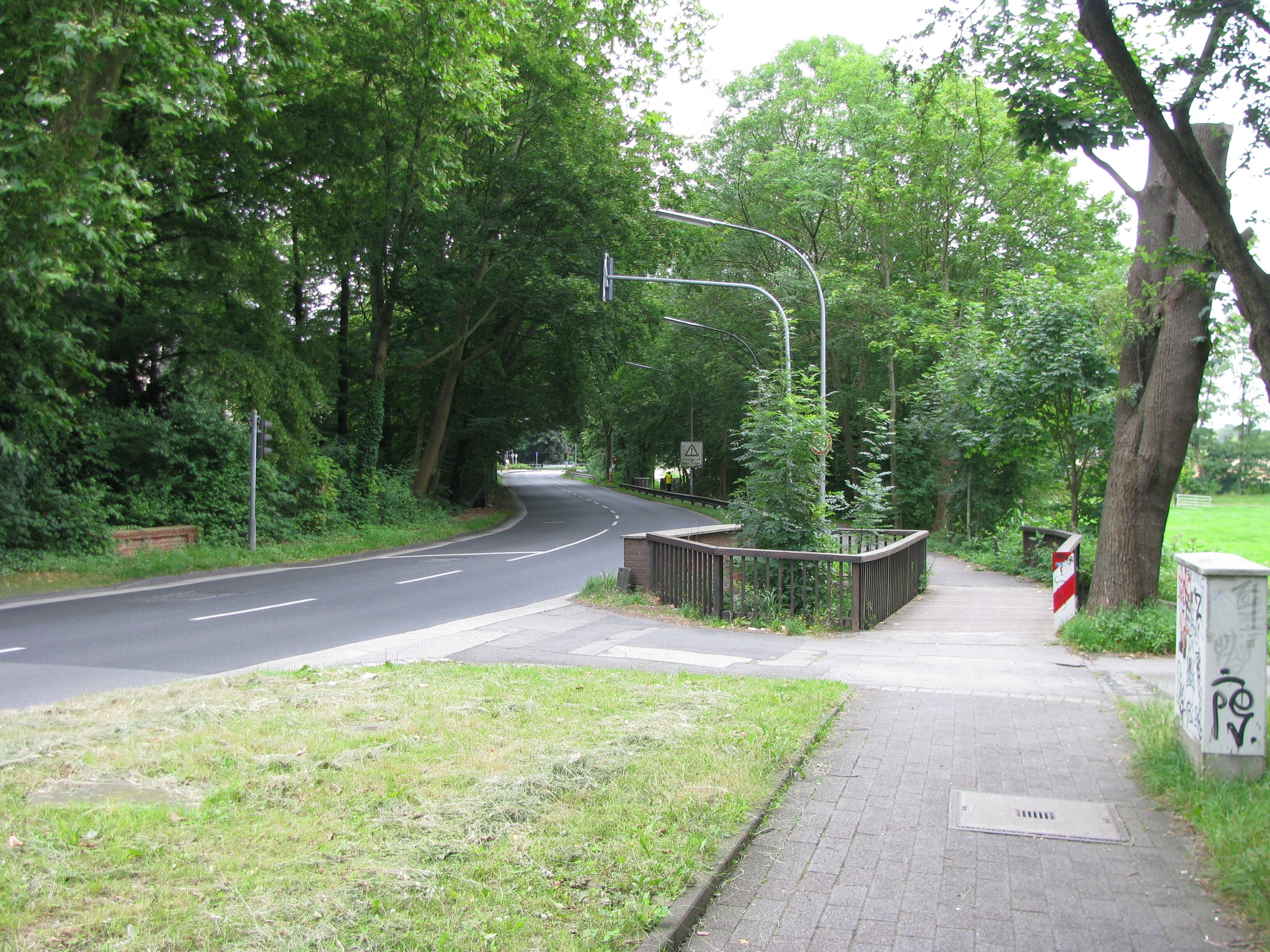 der Buchheimer Ring in Köln-Buchheim, Blick von der Einmündung Schlagbaumsweg in Richtung Norden, die Straßenbrücke und die Fahrradwegbrücke führen über die Strunde, in der Bildmitte ist die Brücke über den Faulbach zu erkennen