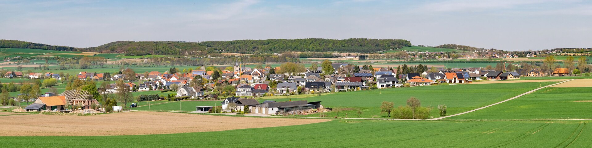 A rural village with houses, fields, and a church.