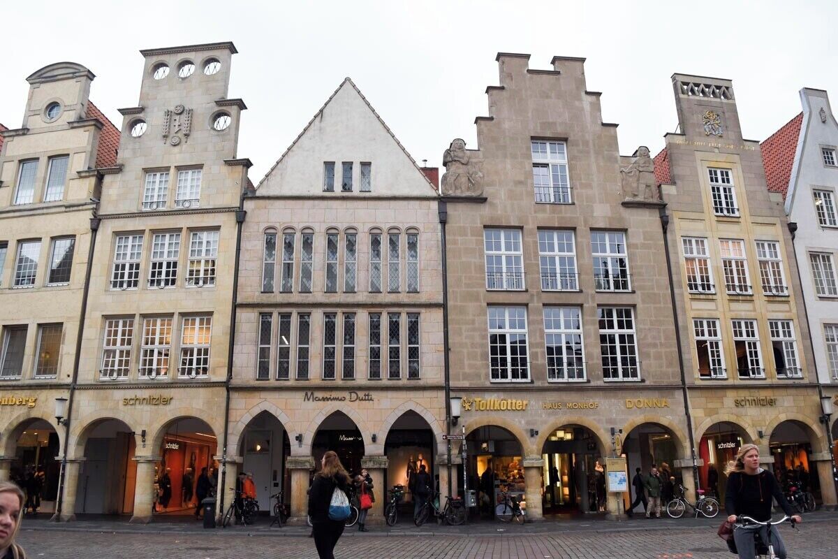 Une rue historique d’Europe, caractérisée par son architecture traditionnelle, notamment ses devantures d’échoppes en arc de cercle et son imposante tour de l’horloge.