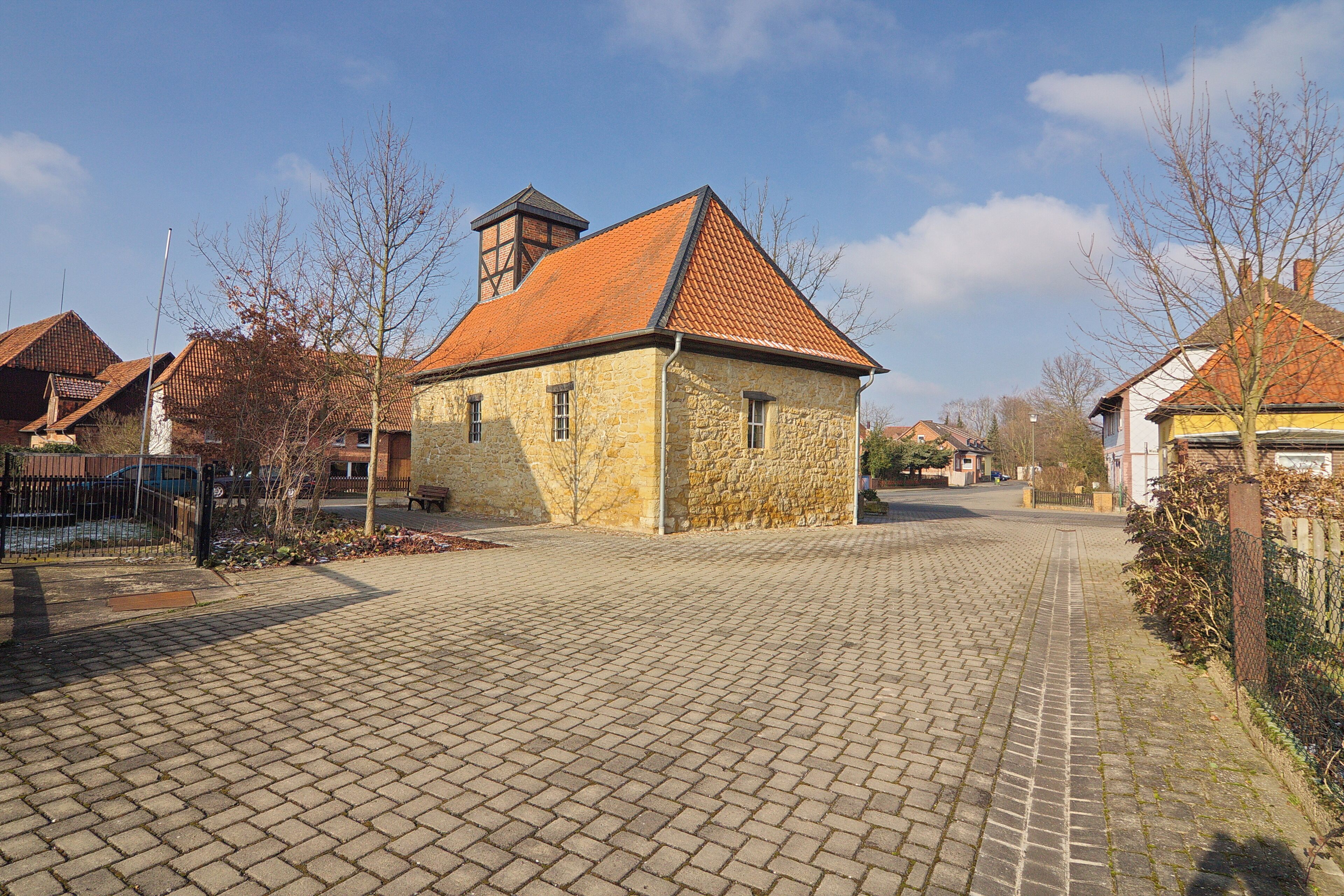 A cobblestone street lined with stone houses and a clear blue sky.