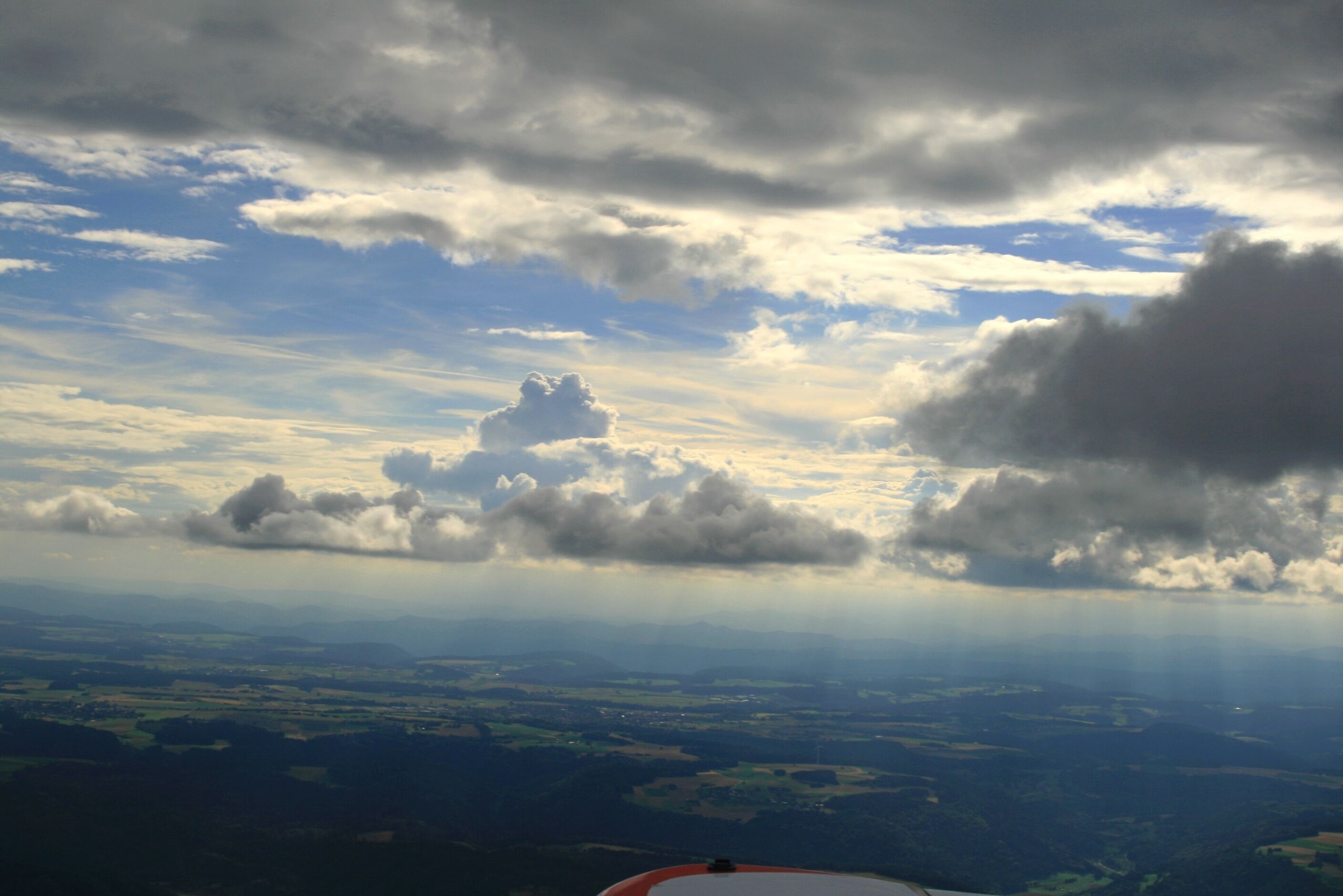 A landscape with clouds and a view of the countryside.