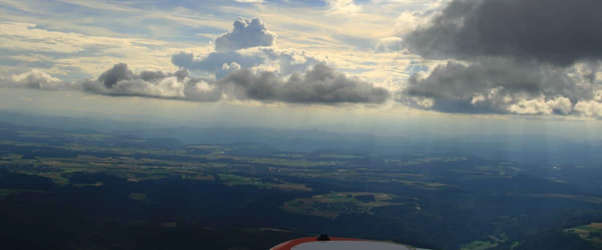 A landscape with clouds and a view of the countryside.