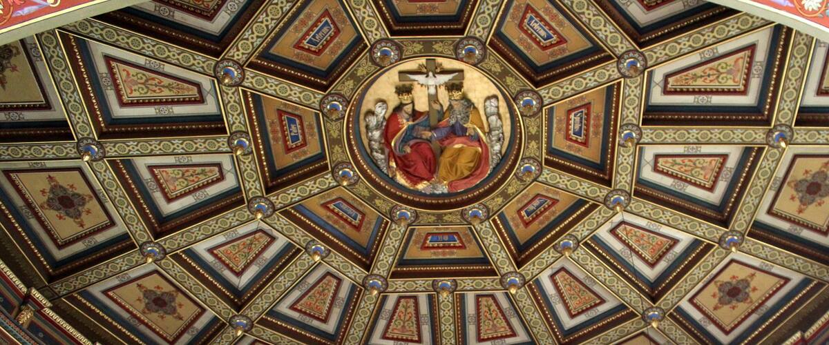 A detailed ceiling with geometric patterns and a central religious figure.