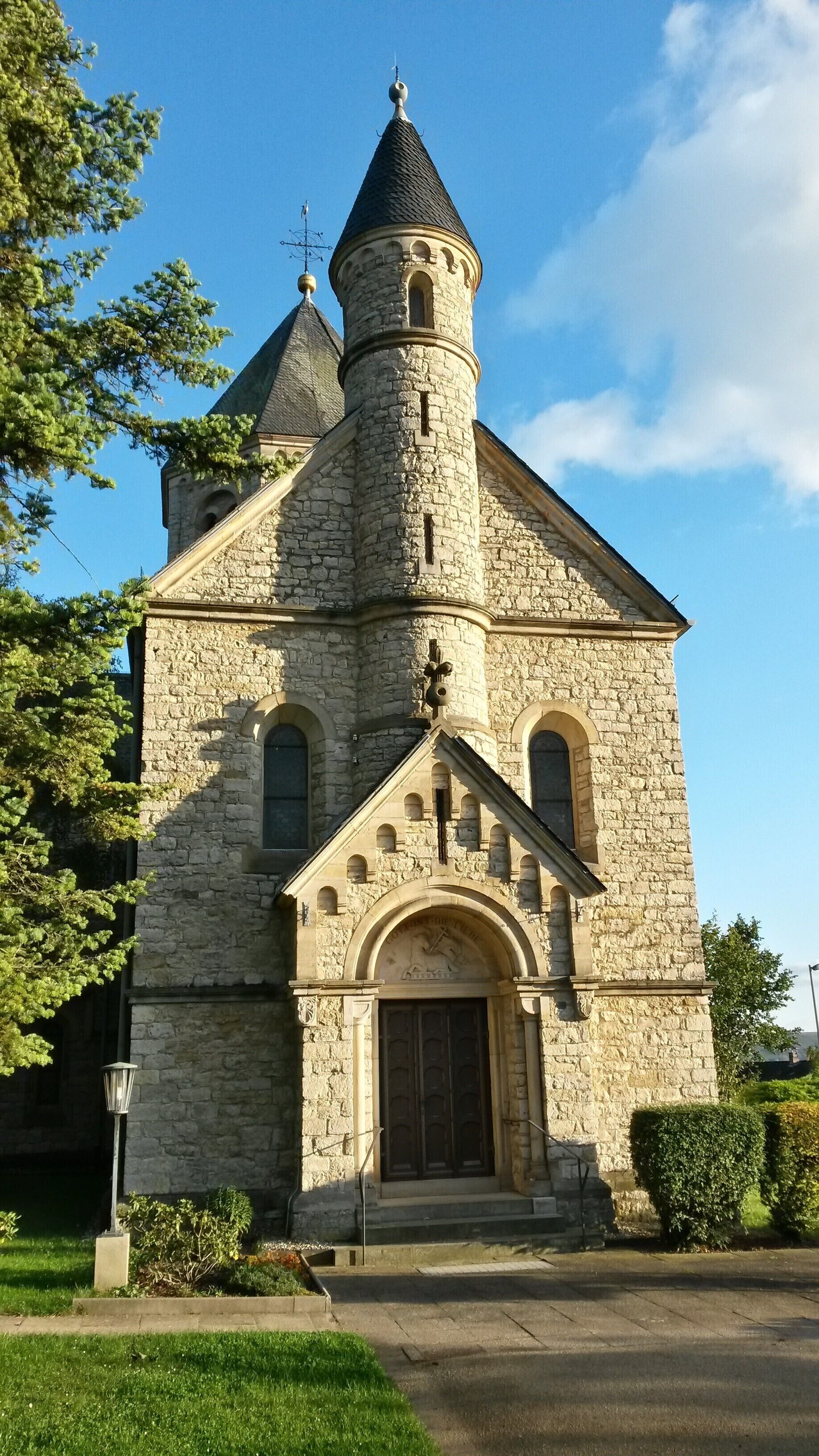 A stone church with a bell tower and arched windows.