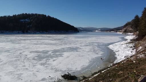 Uusbligg vom Bhf. Seebrugg ubber dè voeiste Schluchsee. Im Vordergrund dè Oschtzipfel vom See, ganz hinnè Ahamer Haaldè mit èm Kapèllèchopf drübber.