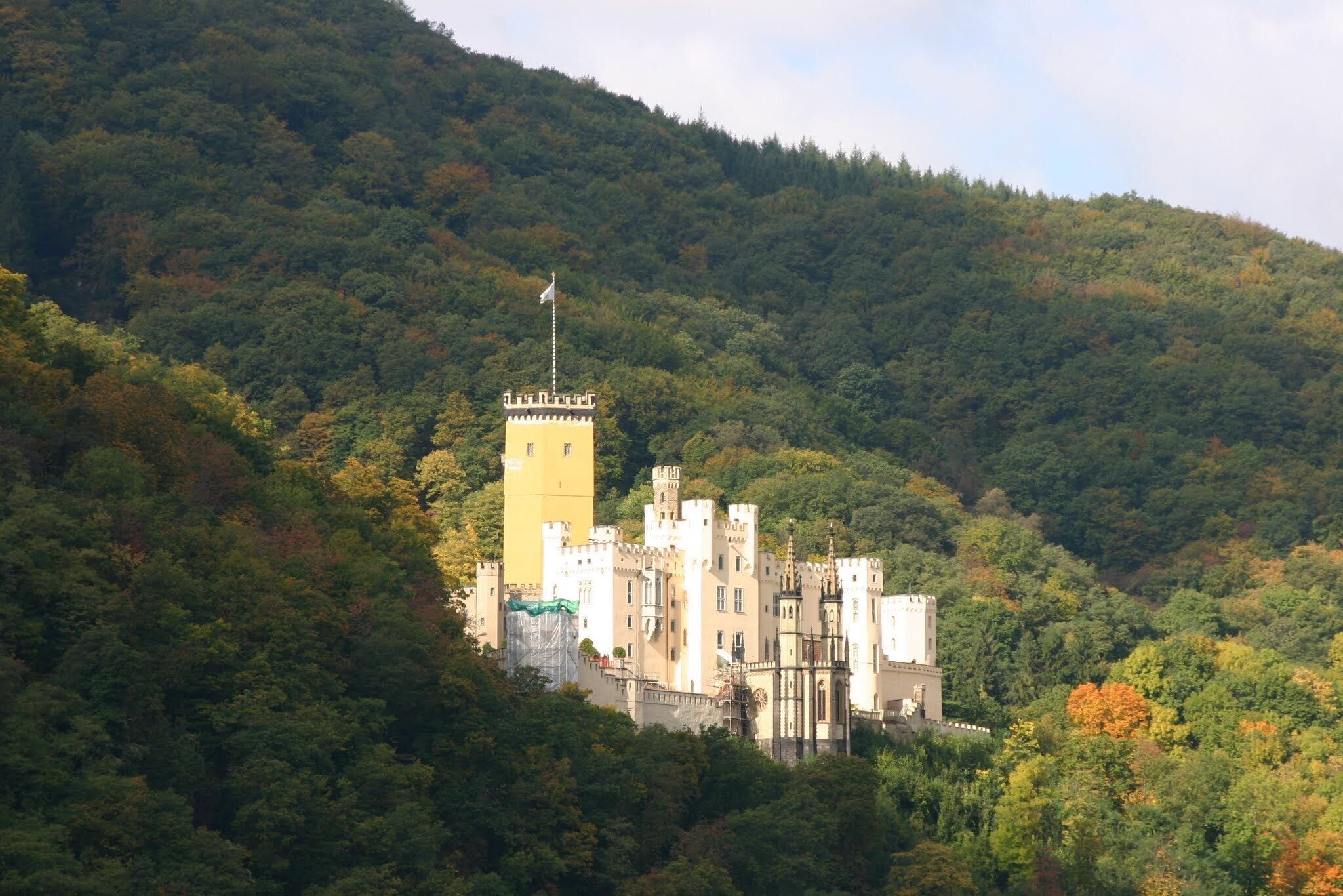 A castle surrounded by forested hills.