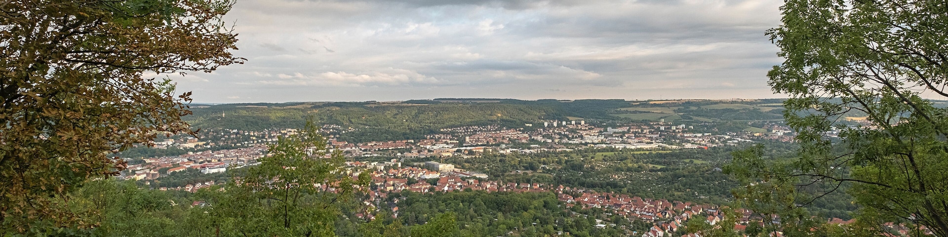 Uma cidade aninhada num vale rodeado por floresta densa.