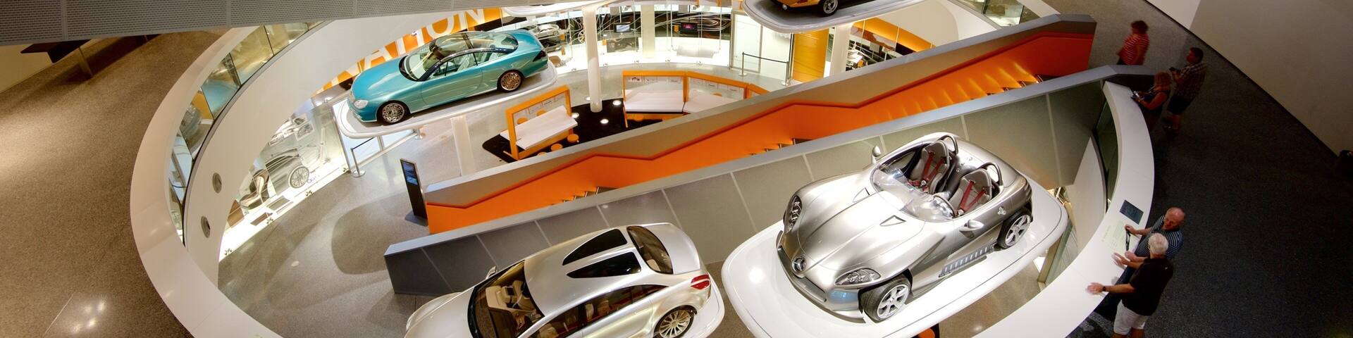 A multi-level car display with various models, including a blue sports car and a silver convertible.