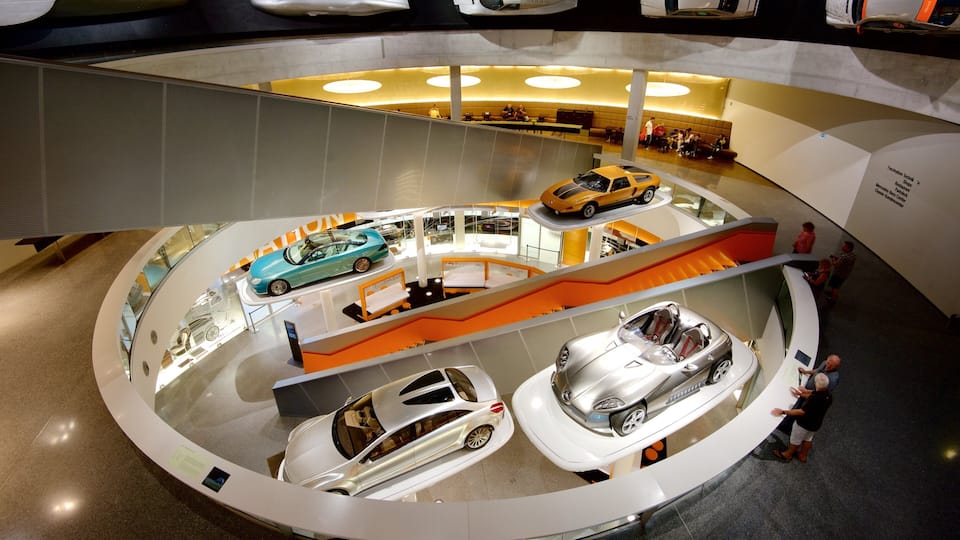 A multi-level car display with various models, including a blue sports car and a silver convertible.