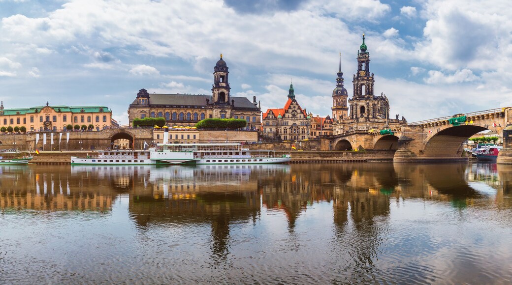 A river with boats, a bridge, and historic buildings with domes and spires.