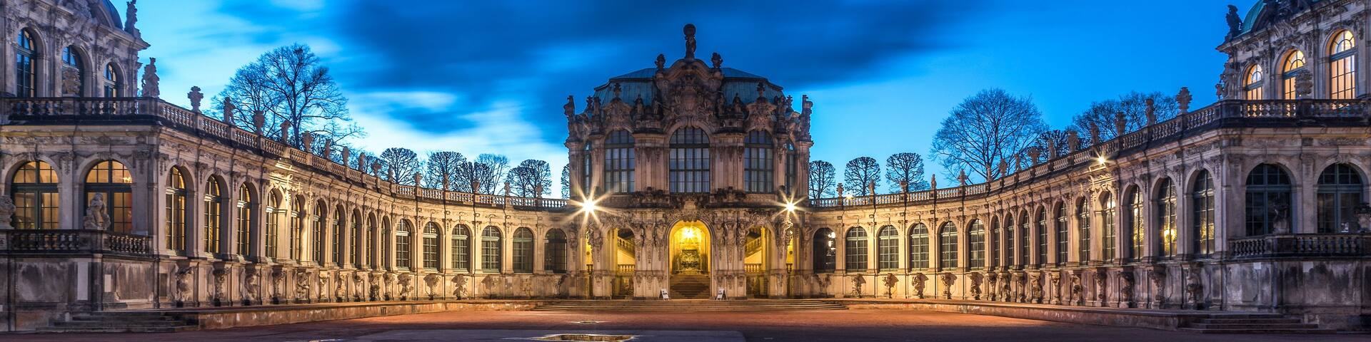 A grand historic building with ornate architecture, large windows, and a symmetrical facade.