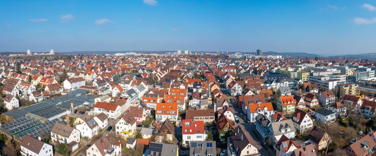 Ein dicht besiedeltes Stadtgebiet mit Wohngebäuden und modernen Hochhäusern.