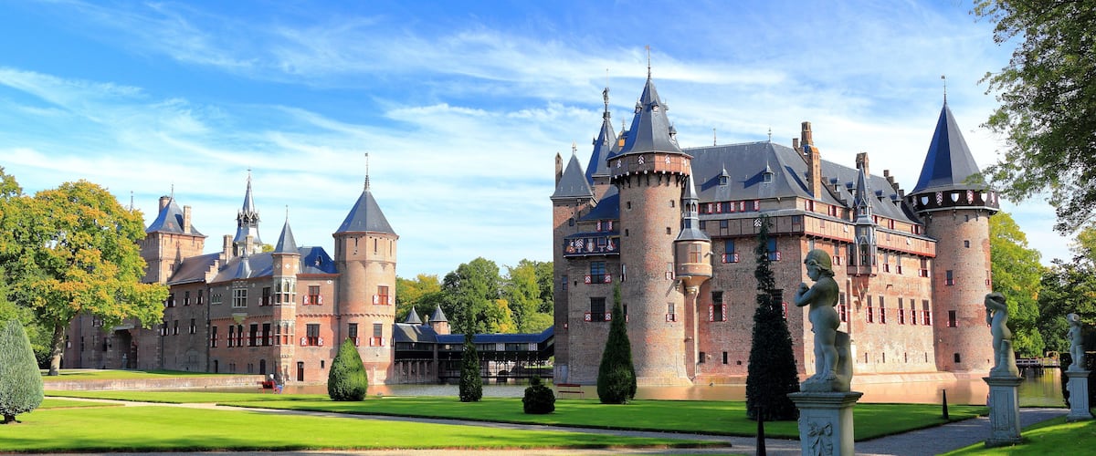 A large castle with multiple towers and a well-maintained garden.