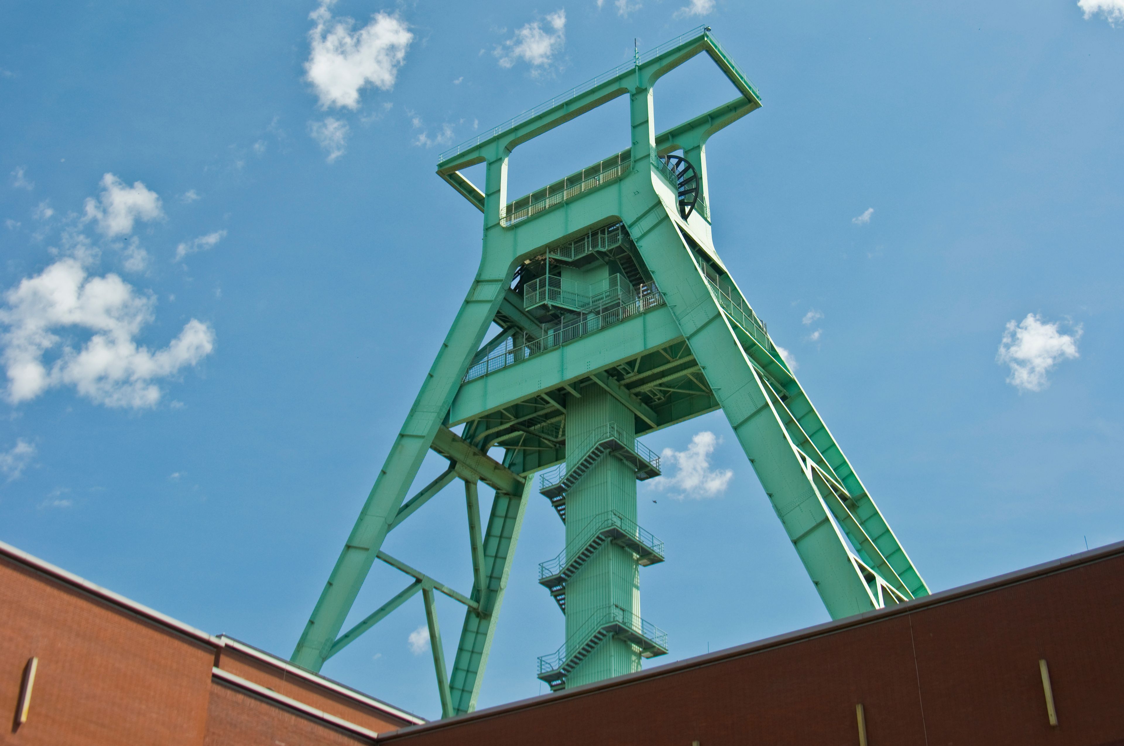 Eine große, grüne Metallkonstruktion vor blauem Himmel.
