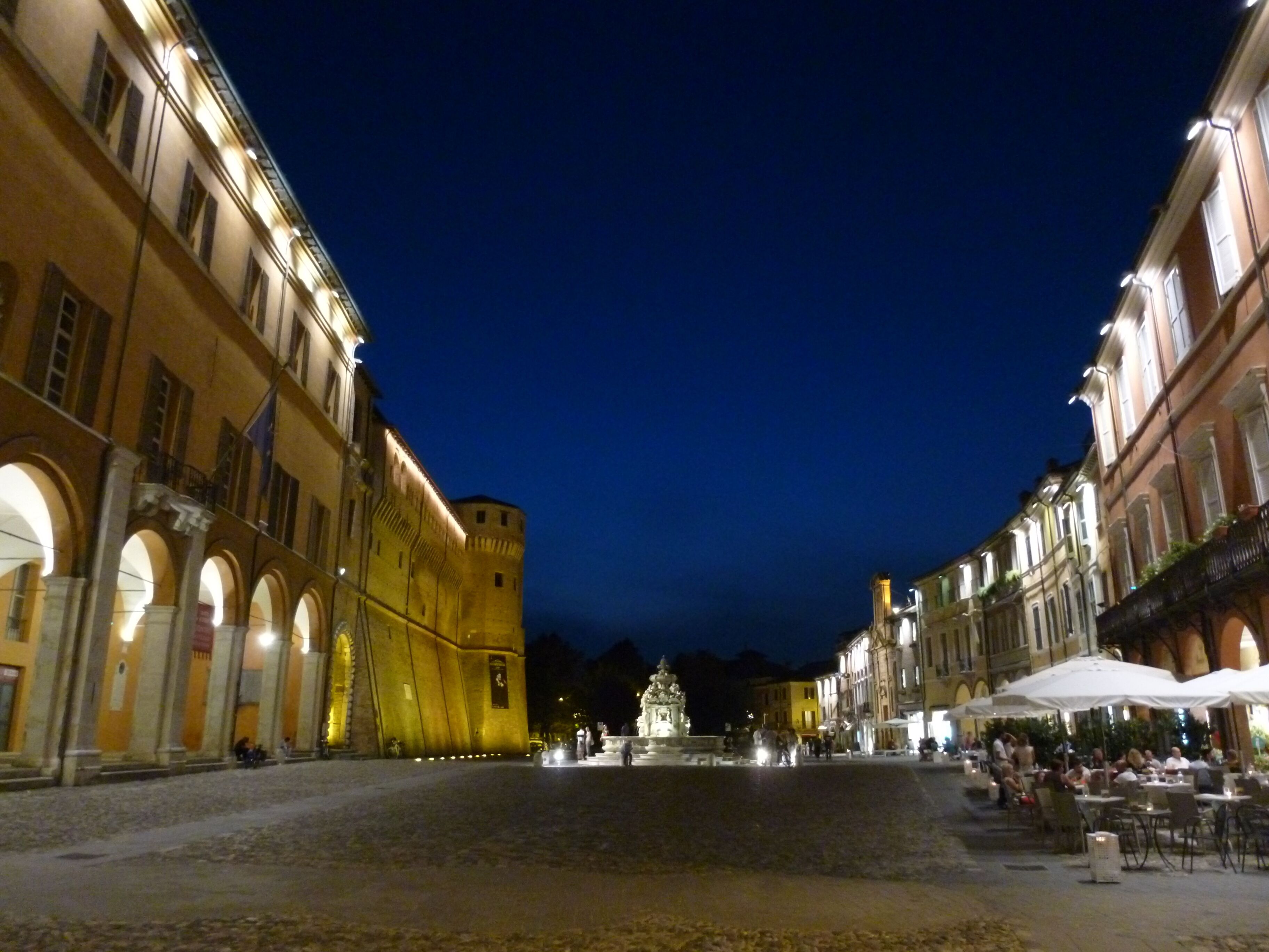 A historic square with a central fountain, surrounded by classical architecture and cobblestone streets.