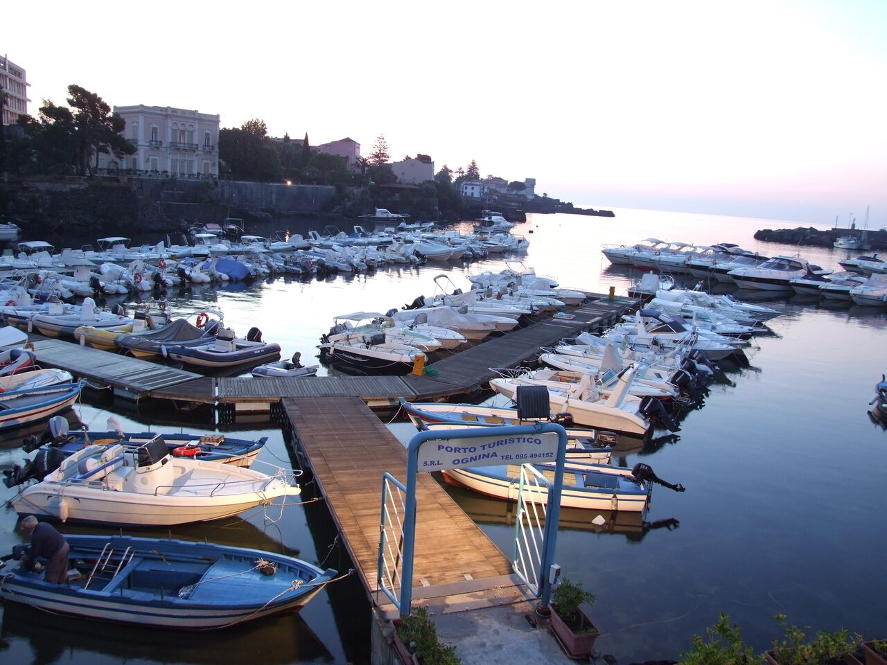 Una marina con numerose imbarcazioni ormeggiate a moli di legno.