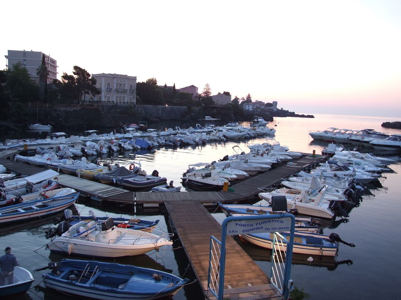 A marina with numerous boats docked at wooden piers.