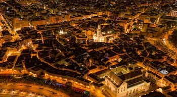 An aerial view of a city at night with illuminated buildings and streets.