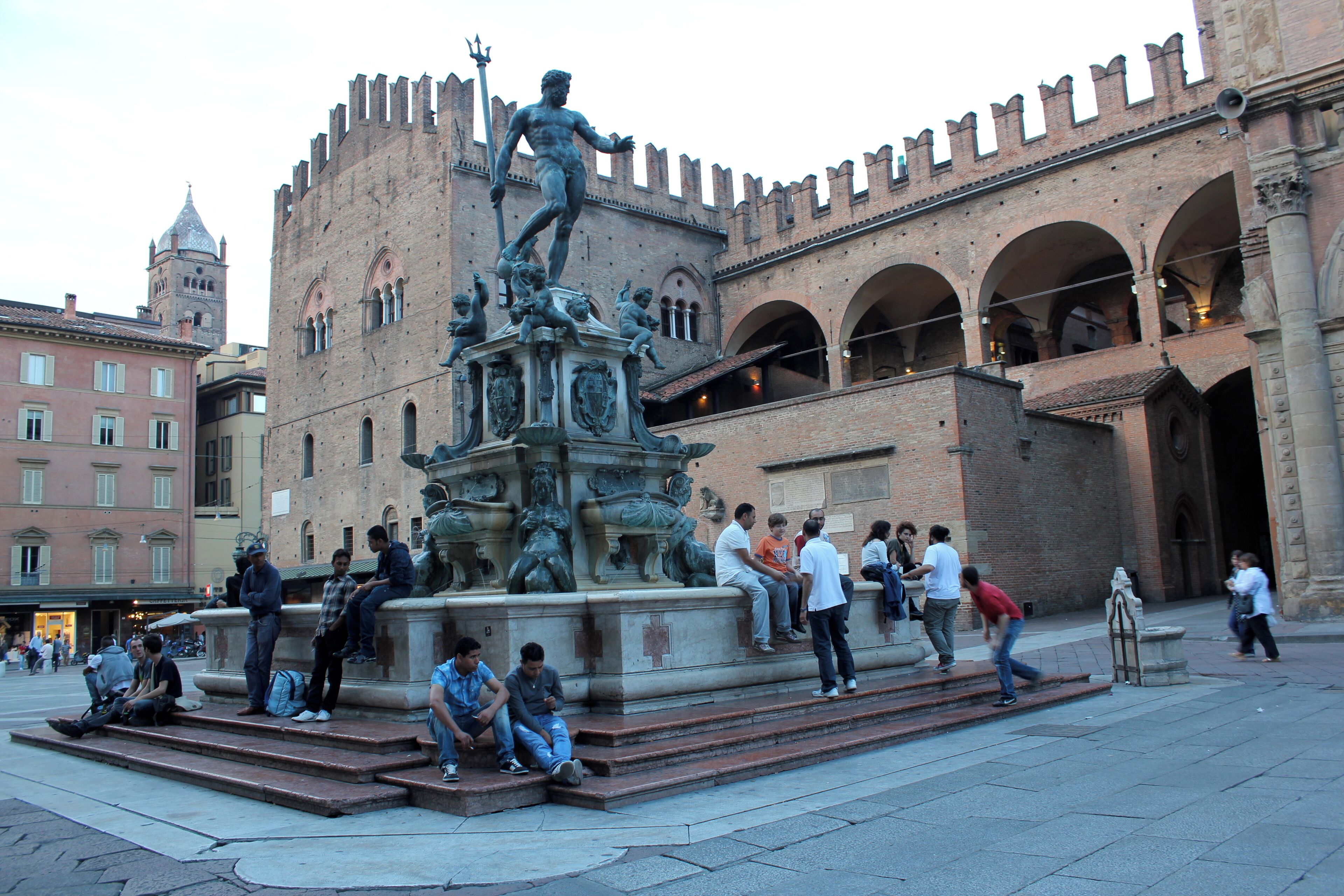 A historical fountain with a statue in front of a castle-like building.