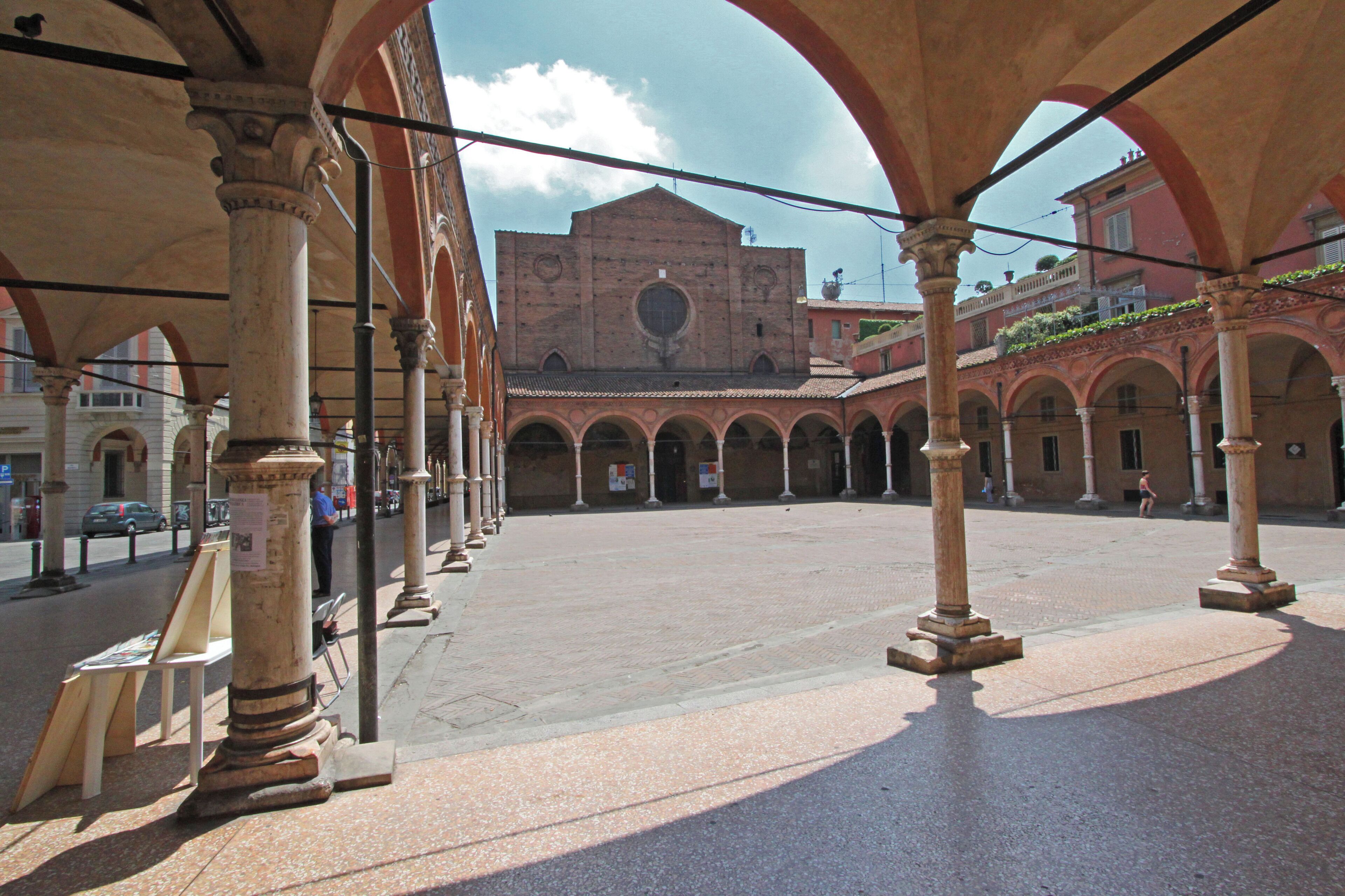 Facciata della basilica di Santa Maria dei Servi (sec. XIV) attraverso gli archi del quadriportico.