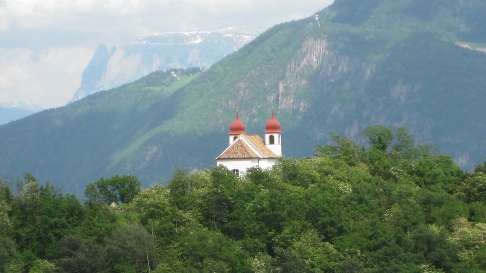 Die Heiligkreuzkirche auf der Gleif (auch einfach Gleifkirche genannt) in Eppan in Südtirol von Westen gesehen, im Hintergrund der Schlern