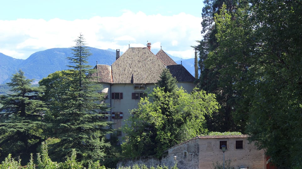 A mountain house surrounded by trees and a clear sky.