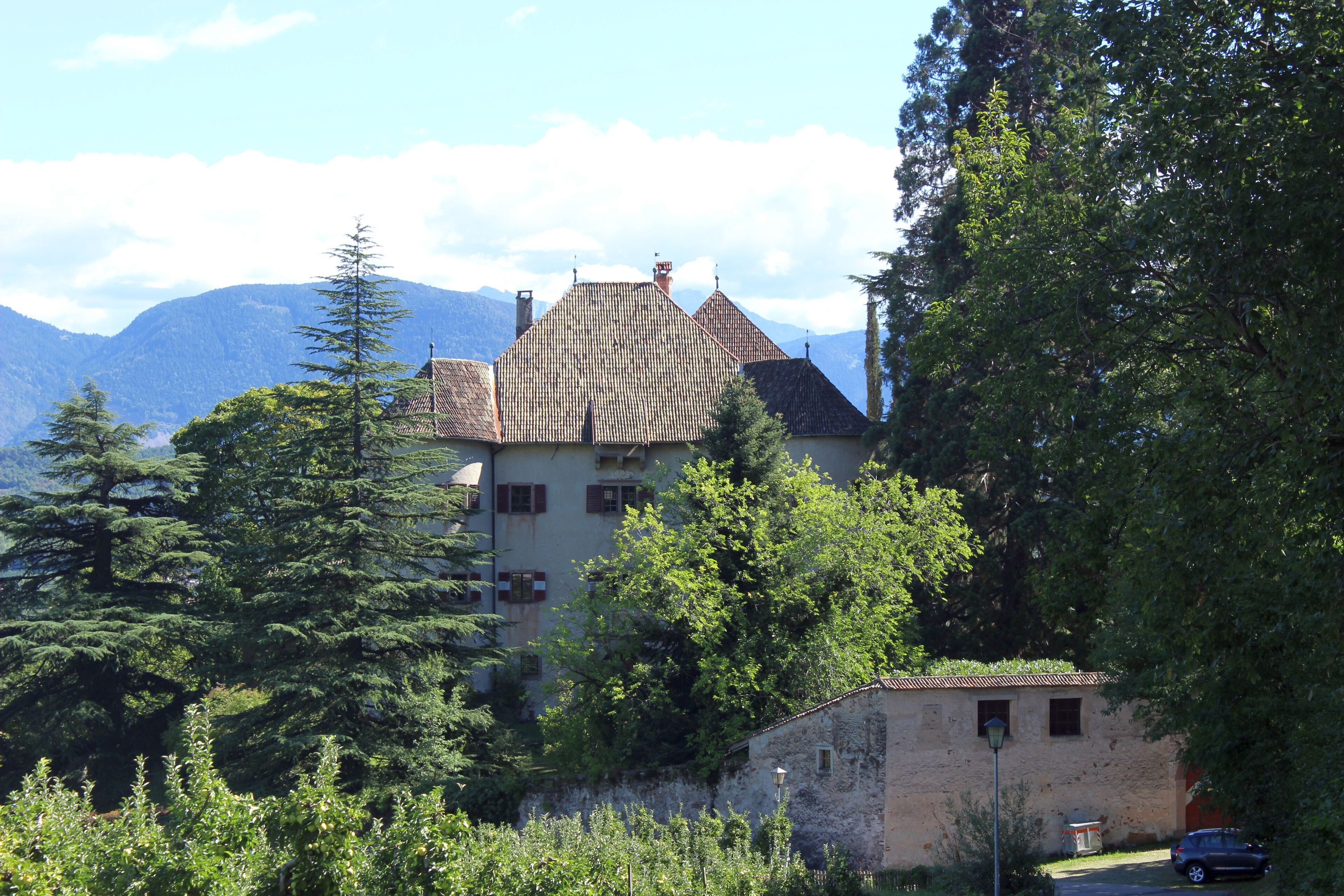 A mountain house surrounded by trees and a clear sky.