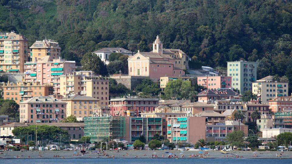 La spiaggia di Multedo a Genova. Sullo sfondo, la caratteristca forma del monte Gazzo di Sestri Ponente, dovuta all'attività estrattiva. Sovrastante la spiaggia vi è la chiesa di Santa Maria e dei santi Nazario e Celso
