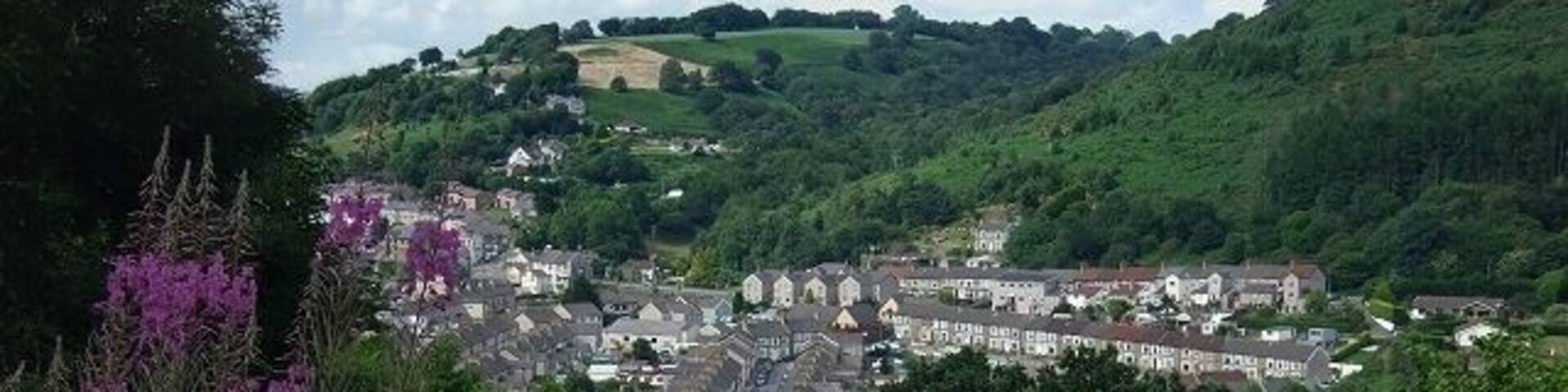 A village nestled in a valley with houses and greenery.