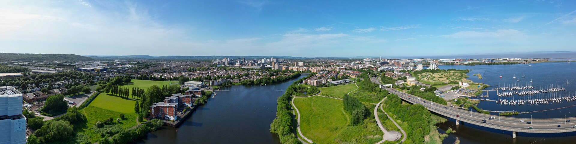 A river winding through a city with a bridge and marina.