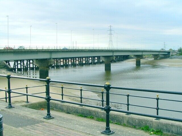 Loughor bridge The road from Llanelli runs over the Loughor estuary towards Gorseinon. Just behind it the supports of the parallel rail bridge can be seen. This is the view from a view point on the east bank, upstream.