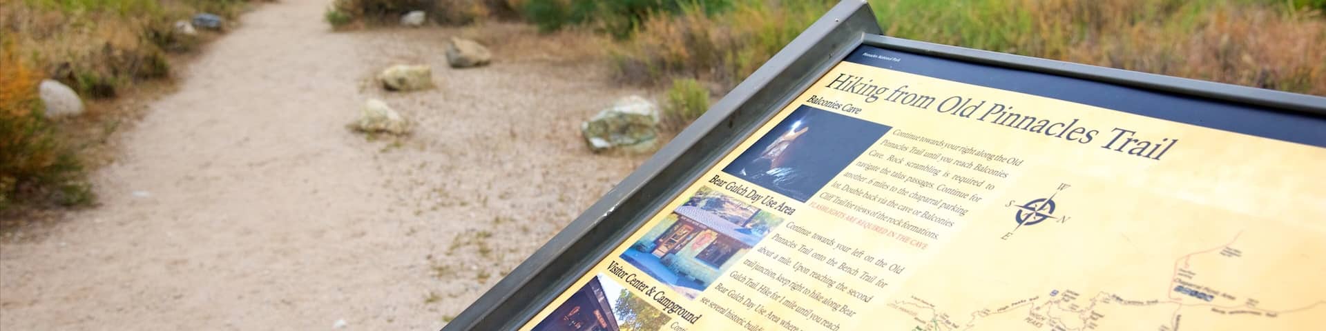 A hiking trail sign with a map and instructions.