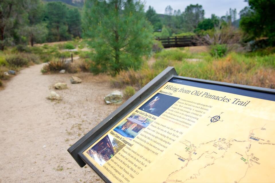 A hiking trail sign with a map and instructions.