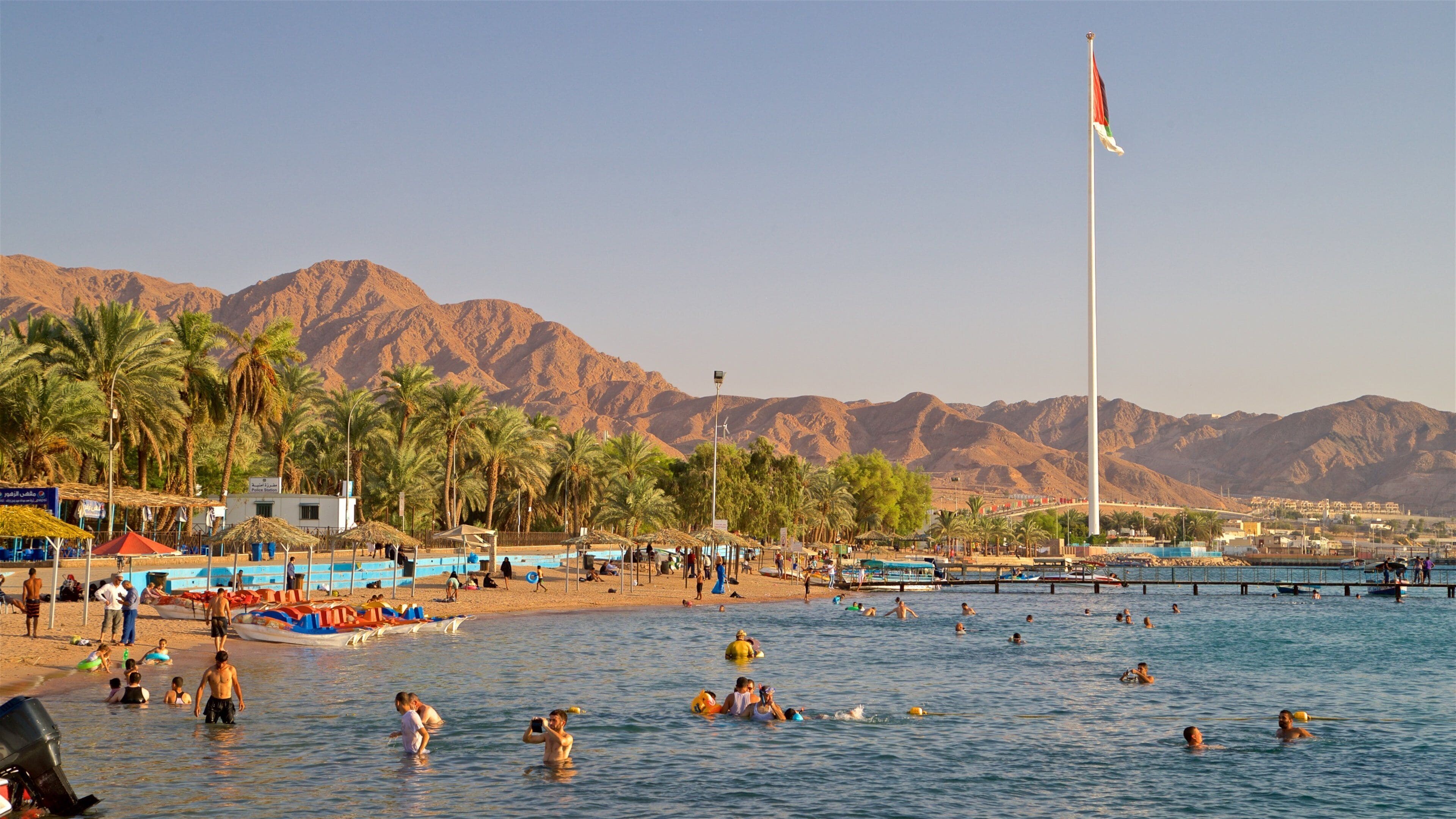 Aqaba som omfatter en strand, svømning og tropiske områder