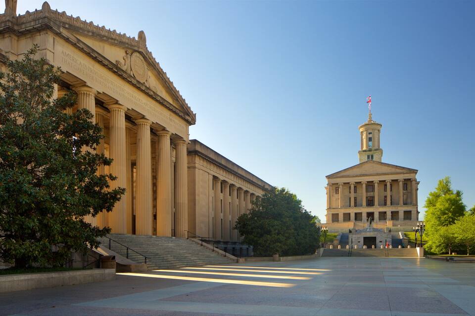 A grand neoclassical building with a central dome and a flag atop.