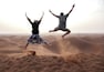 People jump in the Chegaga dunes in the Sahara desert in Morocco.