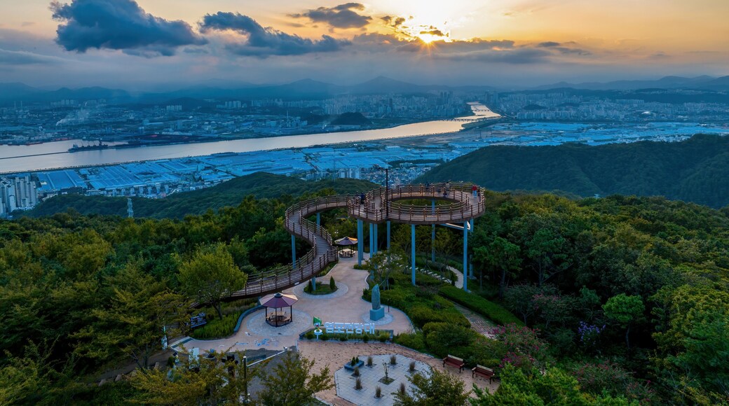 Yeompo-dong, Buk-gu, Ulsan, South Korea - September 11, 2023: Aerial and sunset view of tourists on Yeompo Observatory on Yeomposan Mountain against Taehwa River and apartments