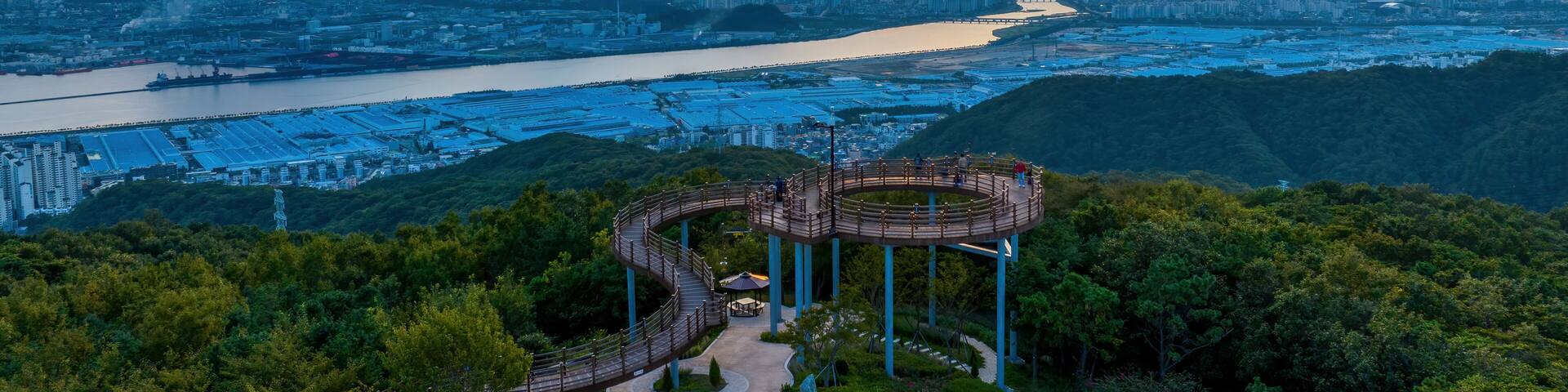 Yeompo-dong, Buk-gu, Ulsan, South Korea - September 11, 2023: Aerial and sunset view of tourists on Yeompo Observatory on Yeomposan Mountain against Taehwa River and apartments