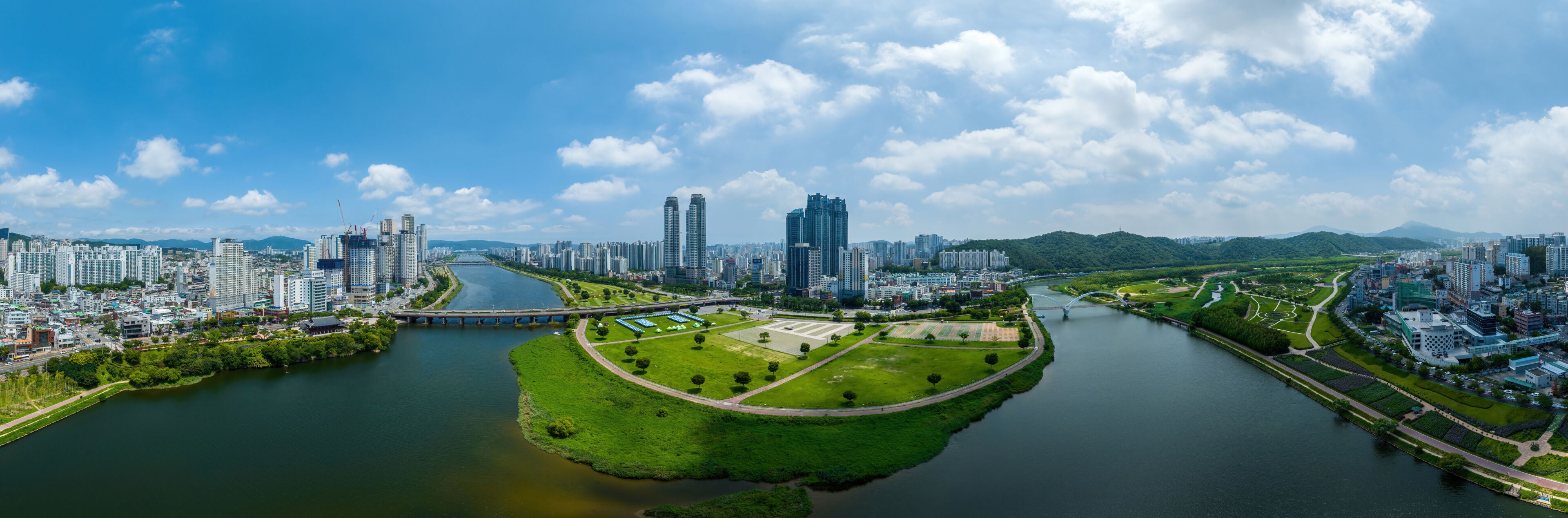 Sinjeong-dong, Nam-gu, Ulsan, South Korea - July 30, 2022: Aerial and panoramic view of Taehwa Bridge on Taehwa River and Ulsan Citizens Park with high rise buildings in summer