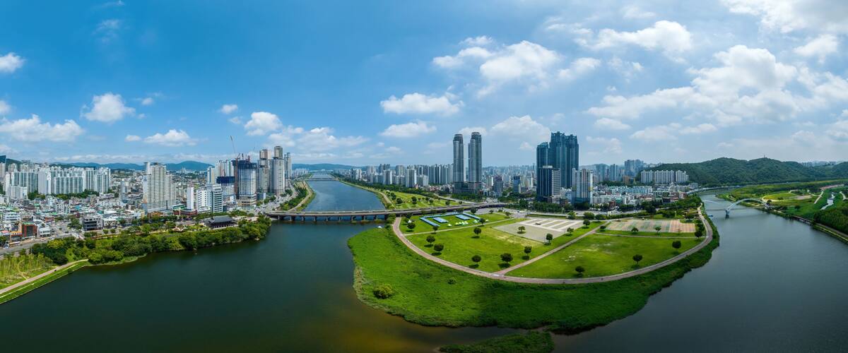 Sinjeong-dong, Nam-gu, Ulsan, South Korea - July 30, 2022: Aerial and panoramic view of Taehwa Bridge on Taehwa River and Ulsan Citizens Park with high rise buildings in summer