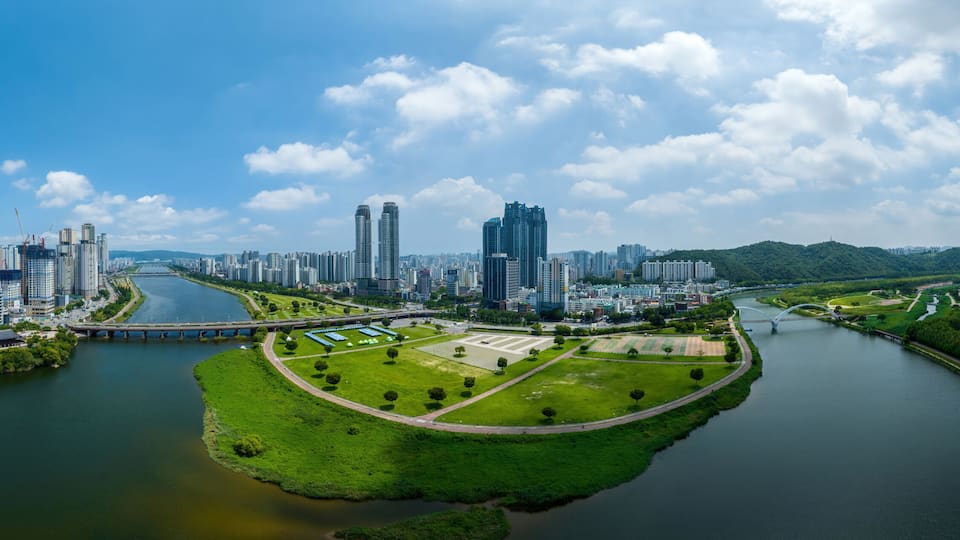 Sinjeong-dong, Nam-gu, Ulsan, South Korea - July 30, 2022: Aerial and panoramic view of Taehwa Bridge on Taehwa River and Ulsan Citizens Park with high rise buildings in summer