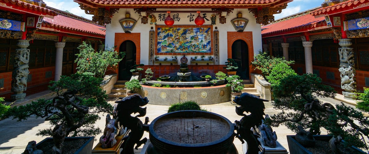 A traditional Chinese temple with ornate architecture, a central courtyard, and statues.